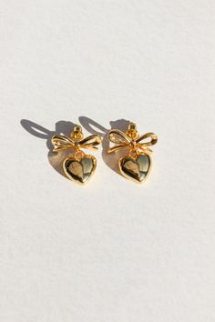 PRODUCT DESCRIPTION Fall in love with our Sweetheart Earrings, featuring an adorable bow and heart design. These charming earrings effortlessly blend whimsy and romance, making them the perfect accessory for any occasion. Gold Statement Earrings Water Resistant 18k Gold-plated on Hight Quality Brass Size: 2.4cm in height Read our full Jewellery Care Guide here Read our Sizing Guide here Dainty Heart-shaped Earrings For Parties, Cute Bow Jewelry For Valentine's Day, Heart-shaped Bow Earrings For Party, Heart Shaped Bow Jewelry For Party, Bow Earrings For Valentine's Day Gift, Heart Shaped Party Jewelry With Bow, Dainty Heart Earrings For Party, Heart Shaped Bow Earrings For Party, Party Heart Earrings With Bow