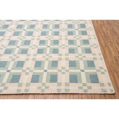 a blue and white rug with squares on the floor in front of a wooden floor