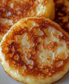 three pancakes on a white plate covered in powdered sugar