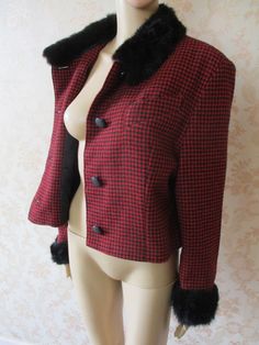 Fabulous cropped jacket in black and red check.  It has Four buttons to close and a top pocket.  The collar and cuffs are trimmed with black faux fur.  Very good condition. Bust flat;  20" Across shoulder flat;  18" Length;  21" Sleeve from shoulder;  22" 60% wool  \  40% viscose Retro Houndstooth Blazer For Winter, Retro Houndstooth Winter Blazer, Retro Winter Houndstooth Blazer, Vintage Black Long Sleeve Tweed Jacket, Retro Wool Tweed Jacket For Winter, Retro Winter Wool Tweed Jacket, Fitted Retro Tweed Jacket For Winter, Red Tweed Winter Jacket, Red Long Sleeve Tweed Jacket For Winter