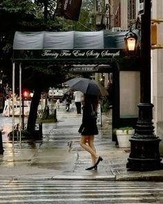 a woman walking down the street with an umbrella