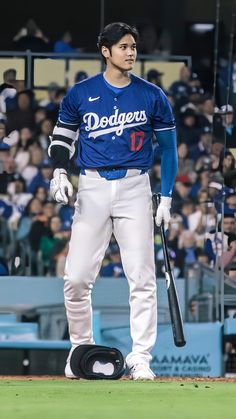 a baseball player holding a bat on top of a field in front of a crowd