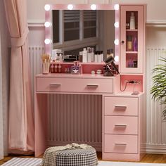 a pink vanity with lights on it in a room