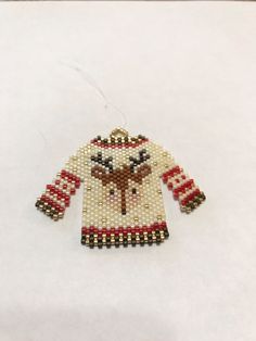 an ornament made out of beads with a sweater on it