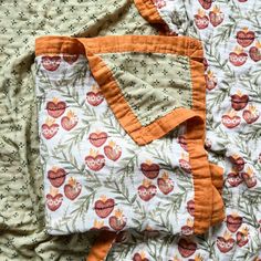 an orange and white quilted blanket laying on top of each other