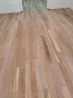 an empty room with hard wood flooring and white trim on the door way to another room