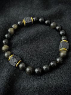 A strongly protective stone, Obsidian is believed to form a shield against negativity and is truth enhancing. It blocks psychic attacks and absorbs negative energies from the environment. There is 1 accent cube Lava Stone bead, which is repeated 3 times for Balance. A grounding stone, Lava Stone is believed to provide stability during times of change and encourages strength and courage. It promotes change where needed for behavioral issues and enhances fertility. Hand-strung Lava Stone Bracelets, Round Obsidian Meditation Bracelets, Hand-strung Obsidian Bracelet, Spiritual Beaded Obsidian Bracelets, Obsidian Beaded Bracelets With 8mm Beads As Gift, Obsidian Round Beads Bracelets For Meditation, Obsidian Round Beads Bracelet For Meditation, Elegant Obsidian Bracelets For Meditation, Spiritual Obsidian Round Beads Bracelet