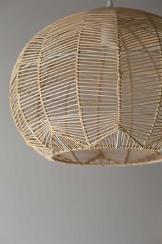 a rattan light fixture hanging from a ceiling