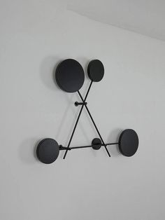 a clock that is on the wall with black circles and sticks in front of it