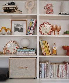 the bookshelf is filled with many different items