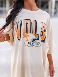 Get your game on with the Vols Helmet Fade Oversized Tee! This officially licensed shirt gives you an old school look while showing your love for the University of Tennessee. With a quirky style and playful tone, this tee is perfect for any true fan. Go Vols! Throwback Crew Neck Top For Game Day, Throwback Graphic Print Tops For Football Season, Retro Oversized Tops For Game Day, Oversized Retro Top For Game Day, Throwback Relaxed Fit Tops For Game Day, Relaxed Fit Throwback Tops For Game Day, Collegiate Oversized Top With Graphic Print, Oversized Collegiate Top With Graphic Print, Retro Oversized T-shirt For College