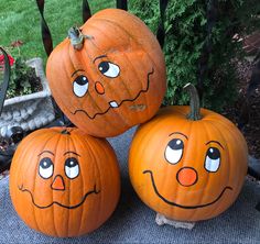 three pumpkins with faces painted on them