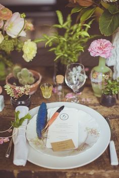 the table is set with flowers and place settings