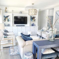 a living room filled with furniture and a flat screen tv mounted to the side of a wall