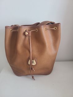 Vintage Authentic Large Lancel Paris Leather Bucket Bag in yummy caramel.  Measurements approx. :  Length: 26cm Depth: 12cm Height: 32cm Made in France.  Strap is adjustable.   In very good condition.  Buyers, kindly indicate your contact number when making a purchase. All photos were taken under natural lighting. I do not use any filters on my photos. These items were preloved, which means they have a life prior to this. Hence some imperfections maybe found. I try my very best in show these imp Formal Brown Shoulder Bag With Snap Closure, Classic Brown Pouch Bucket Bag, Classic Brown Bucket Shaped Bag, Brown Leather Bucket Bag With Snap Closure, Vintage Leather Bucket Bag, Vintage Leather Bucket Shoulder Bag, Brown Bucket Bag With Snap Closure, Brown Bucket-shaped Formal Bag, Formal Brown Bucket-shaped Bag