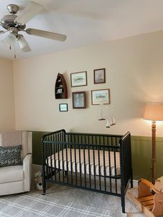 a baby crib in a room with pictures on the wall