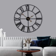 a living room with a couch, table and large clock on the wall above it