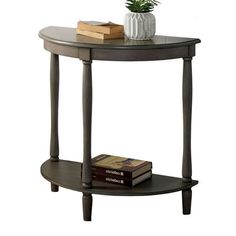 a table with a plant on top of it next to a book and some books