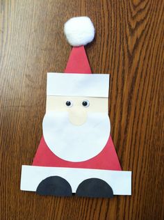 a paper santa clause with a pom - pom on it