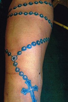 a person with a rosary tattoo on their arm and foot is seen from the waist up