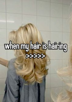 a woman with blonde hair standing in front of a bathroom mirror and looking at her reflection