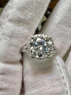 a diamond ring sitting on top of a white glove