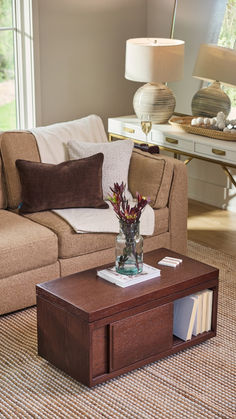 a living room with a couch, coffee table and lamp on the side walk way