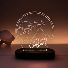 a light up christmas ornament with santa on his sleigh in the background