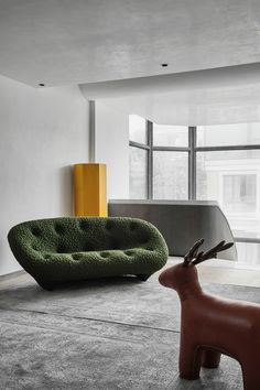 a living room filled with furniture and a deer statue in the middle of the room