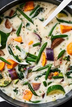 a pot filled with soup and vegetables on top of a stove