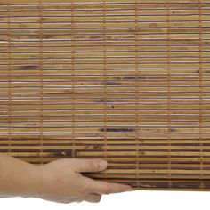 a hand is holding a bamboo mat