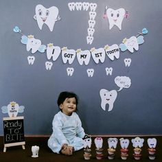 a little boy sitting on the floor in front of some toothbrushes and cupcakes