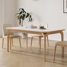 a table and chairs in a room with white walls, hardwood floors and wooden flooring