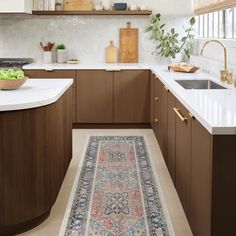 a rug is in the middle of a kitchen with wooden cabinets and countertops