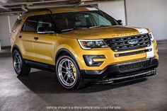 a yellow ford explorer is parked in a garage