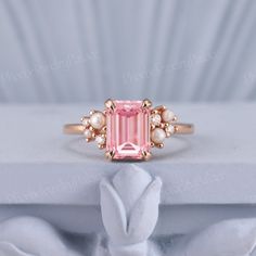 Vintage Emerald Cut Pink Sapphire Engagement Ring Unique Rose Gold Wedding Rings for Women Inspire Flora Ring Anniversary Gift Custom Ring PRODUCT SUMMARY Metal Type: yellow, white or rose solid 14 or 18k gold. Size: All sizes are available, contact me if they do not contain the size you want in the drop-down menu. ☪☪Engagement ring ⚜Center Stone - Lab Grown Pink Sapphire Cut - Emerald Size - 6x8mm ⚜Side Stone 1 - Natural Freshwater Pearl ⚜Side Stone 2- Moissanite or Natural Diamond Cut - Round Weight - 0.13ct Clarity - SI-VS Color- G-H ⚜Band width - 1.8mm IMPORTANT INFORMATION  ☪Shipping ⚜It usually takes 2-3 weeks for production and 1-5 days for shipping to most US destinations. Free shipping within US. ⚜If you want to receive your ring sooner, rush order and shipping upgrade services ar Vintage Pink Ring, Pink Diamond Engagement Ring Vintage, Pink Diamond Engagement Ring Rose Gold, Gold Wedding Rings For Women, Sapphire Engagement Ring Unique, Pink Stone Engagement Rings, Rose Gold Wedding Rings, Pink Sapphire Engagement Ring, Pink Engagement