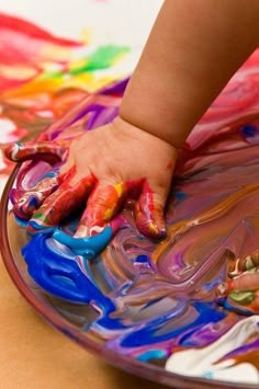 a toddler's hands on a plate with paint