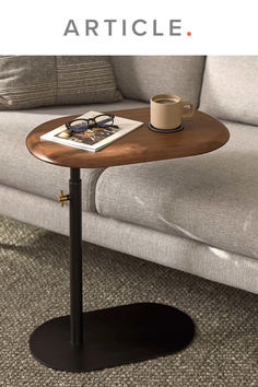 a coffee table sitting on top of a carpeted floor next to a gray couch