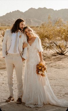 a bride and groom standing in the desert