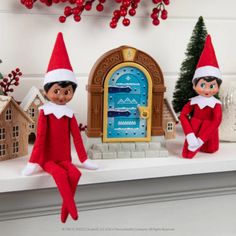 three elfs are sitting on a mantle with christmas decorations