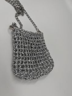 a silver chain purse on a white surface