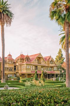 a large brown house surrounded by palm trees