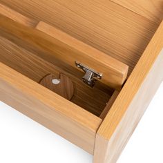 an open drawer with a wooden handle on the bottom and two metal latches at the top