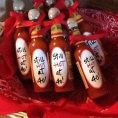 six hot sauce bottles with the words still hot at 40 written on them in black ink