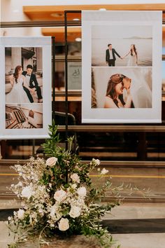 two pictures hanging on the side of a building with flowers in front of them and an arrangement of greenery