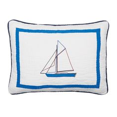 a pillow with a sailboat embroidered on the front and blue trim around the edges