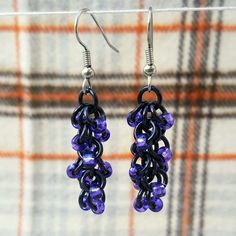 Black anodized aluminum rings with Purple Silver-lined beads. Has surgical steel earwires Length 1.25 inches Adjustable Purple Metal Earrings, Purple Metal Earrings, Hypoallergenic Metal Beaded Drop Earrings, Adjustable Hypoallergenic Purple Beaded Earrings, Purple Beaded, Nature Earrings, Chain Maille, Black And Purple, Anodized Aluminum