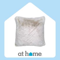 a white pillow sitting on top of a blue and white background with the words at home