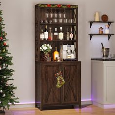 a christmas tree is next to a wooden cabinet with liquor bottles and stockings on it