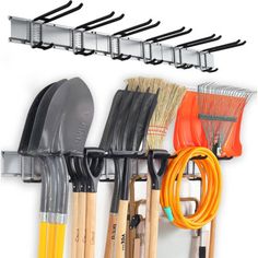 a wall mounted rack with brooms, rakes and other tools hanging on it